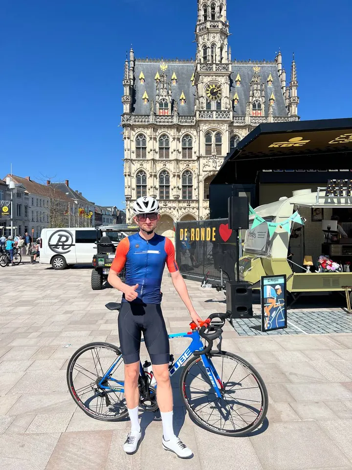 Vitaliy con una bicicletta da strada a un evento ciclistico in Belgio